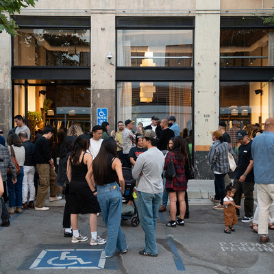 A ton of people hanging out outside a shop.