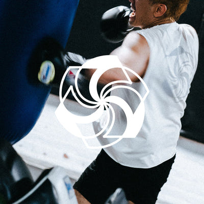 A man in a white tee punches a blue punching bag.