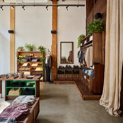 A storefront with plants on shelves and dark wood fixtures.